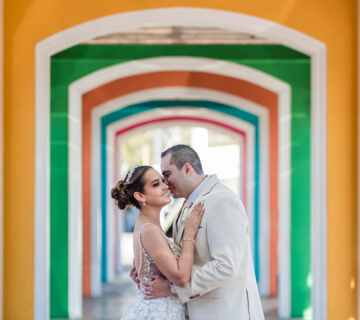 bride and groom hugging and getting close in a colorful tunnel
