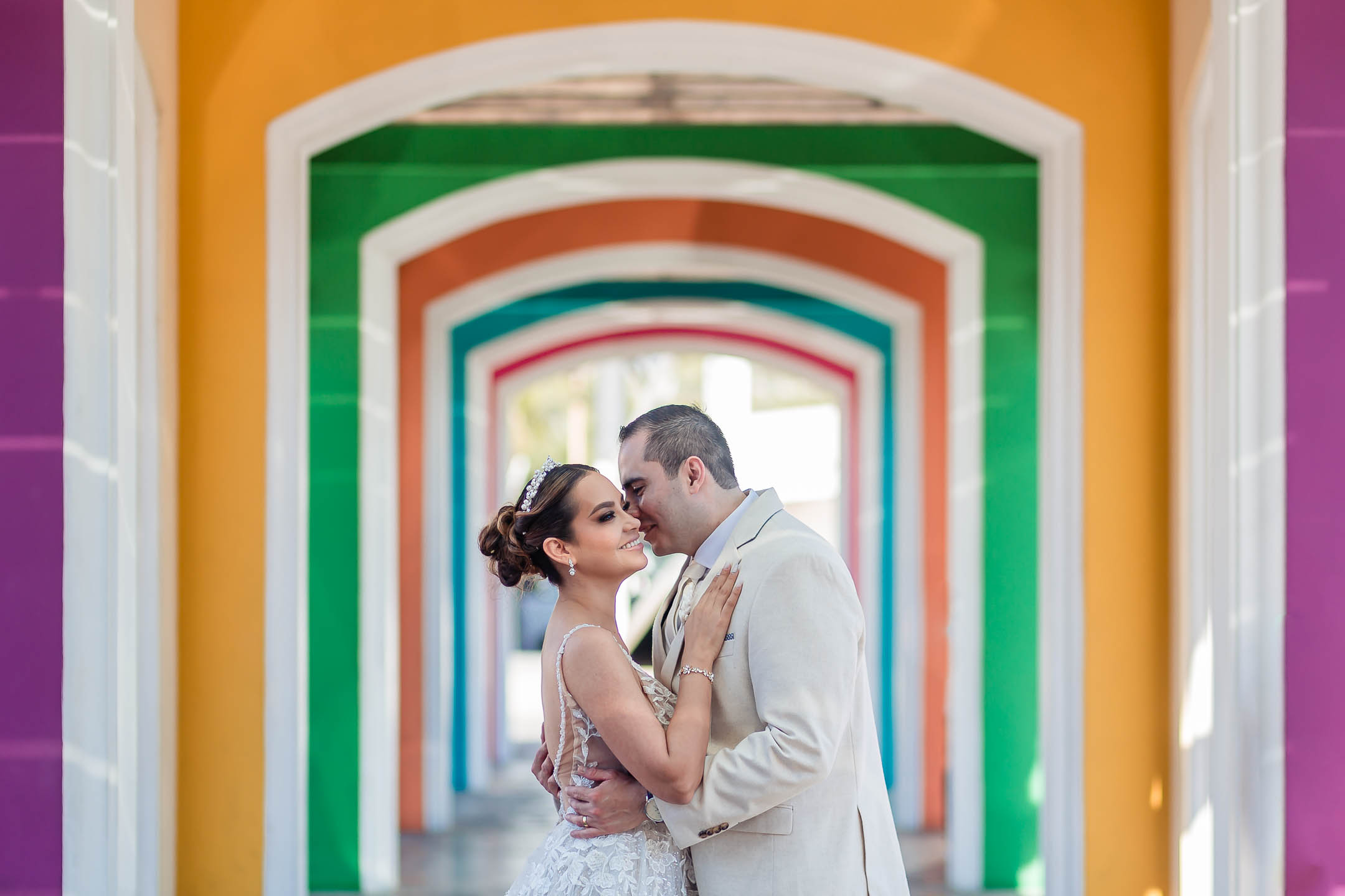 bride and groom hugging and getting close in a colorful tunnel