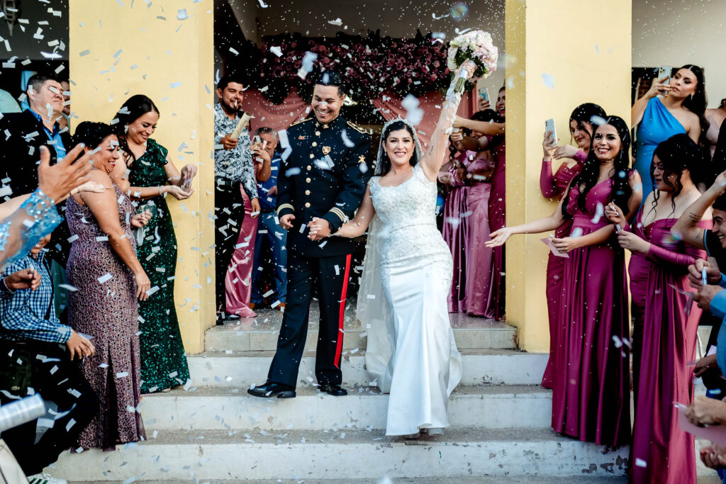 bride and groom going out from the church after the ceremony, they are happy and smiling, the guest are through confetti