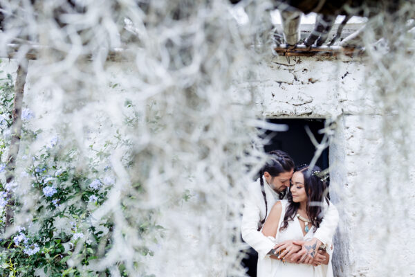 bride and groom ar hugging each other in a sweet moment, there is a little bit of out of focus in front of the camera